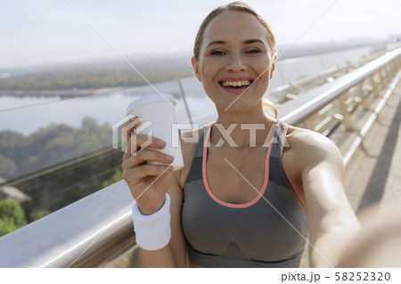 Cheerful sportive lady making selfie on bridge Cheerful sportive lady making selfie on bridge 58252320