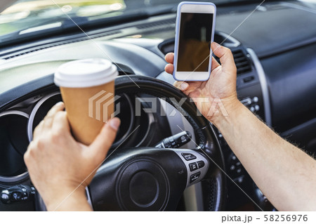 Man keeping cellphone and driving his car Man keeping cellphone and driving his car 58256976