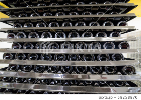 Racks with bottles of wine lie on top of each other in the production area 58258870