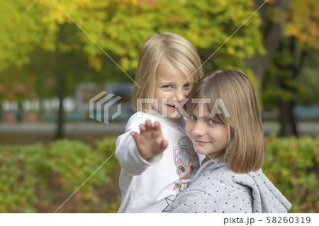 Two happy girls are playing in the autumn park. 58260319