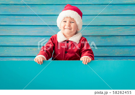 Happy child holding blue Christmas banner blank Happy child holding blue Christmas banner blank 58262455