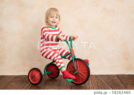 Happy child wearing Santa Claus costume playing at 58262460