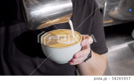 Cropped shot of a barista adding hot milk into coffee in a cup Cropped shot of a barista adding hot milk into coffee in a cup 58265957