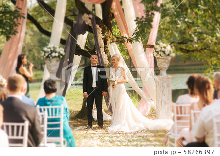 Wedding couple on ceremony outside. beautiful bride and handsome groom. Just married Wedding couple on ceremony outside. beautiful bride and handsome groom. Just married 58266397