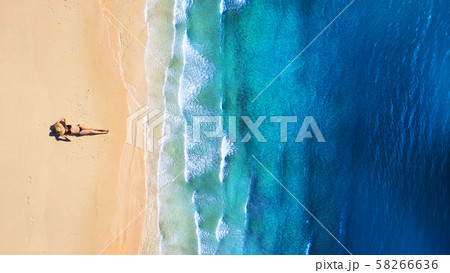 Aerial view of a girl on the beach. Beach and turquoise water. Aerial view of a girl on the beach. Beach and turquoise water. 58266636