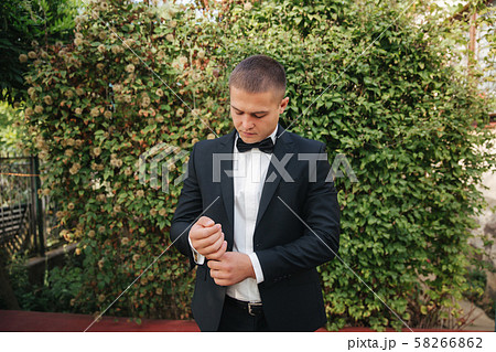 Handsome groom dressed his wedding blazer. autumn weather Handsome groom dressed his wedding blazer. autumn weather 58266862