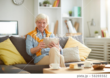 Smiling Senior Man Using Tablet at Home Smiling Senior Man Using Tablet at Home 58269382