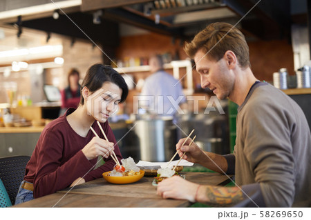 Couple Enjoying Asian Food in Cafe Couple Enjoying Asian Food in Cafe 58269650