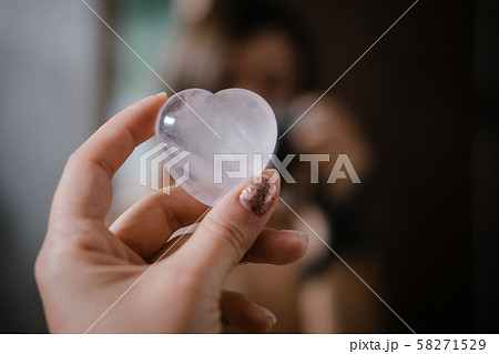 Woman holds rose quartz heart crystal Woman holds rose quartz heart crystal 58271529