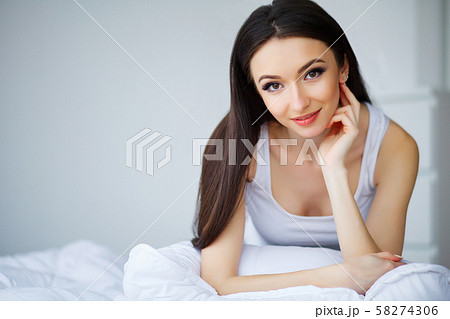 Healthy Happy Female Model Relaxing Indoors. Portrait of a smiling pretty young brunette woman Healthy Happy Female Model Relaxing Indoors. Portrait of a smiling pretty young brunette woman 58274306