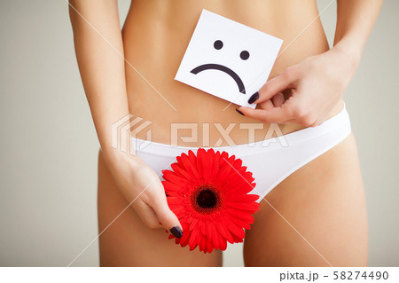 Woman holding paper with sad smile mark over her stomach. Health hygiene sexual education concept 58274490