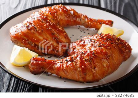 Closeup baked sticky chicken legs quarters served 58274635