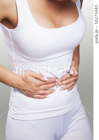 Stomach ache. Painful sensations on the right side of the abdomen. Appendicitis. Young woman holding 58275685