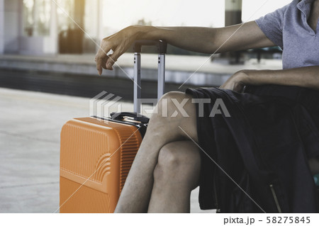 Woman with orange suitcase luggage bag, sitting in 58275845