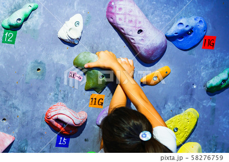[ボルダリング] ボルダのスタジオで女子小学生クライマーが難しい課題に挑戦するシーン（パーツカット） 58276759