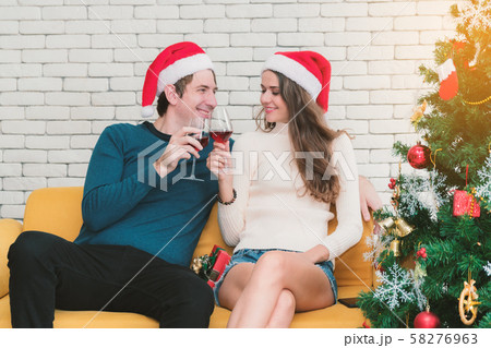 Couple is sitting drinking red wine on the sofa. Couple is sitting drinking red wine on the sofa. 58276963