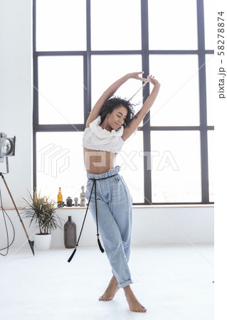 Happy young woman enjoying her dancing alone 58278874