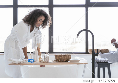 Happy woman checking on the water temperature 58279759