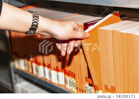Close up womans hand selecting book from bookshelf 58280171