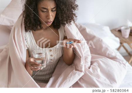 Serious young brunette woman going to take pills 58280364