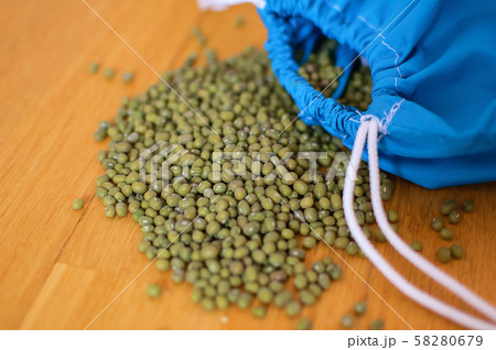 Close up of green mung bean vigna radiata in blue reusable package on wooden background. Eco Close up of green mung bean vigna radiata in blue reusable package on wooden background. Eco 58280679