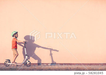 The child is engaged in riding a white scooter. 58281045