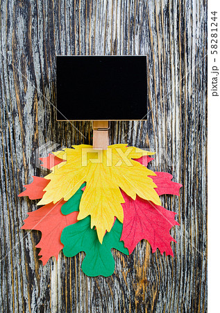Autumn background: chalk board with colorful paper leaves on vintage textured wooden background.  58281244