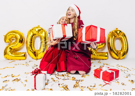 Cheerful mom and her cute daughter in Santa hats, 58282001