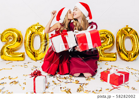 Cheerful mom and her cute daughter in Santa hats, 58282002