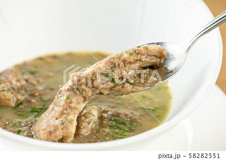 A bowl of homemade chili lentil soup with meat on wooden table. Restaurant menu 58282551