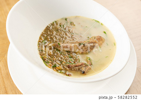 A bowl of homemade chili lentil soup with meat on wooden table. Restaurant menu 58282552