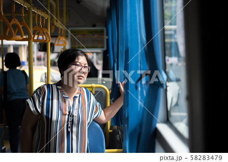 Asian woman travel by passenger bus in city 58283479