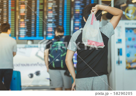 Passengers looking at the flight information board and checking their flight in international airport Passengers looking at the flight information board and checking their flight in international airport 58290205