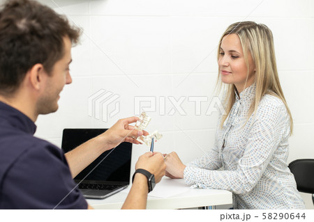The doctor points to the part of the jaw model that the patient has problems with. Selective focus The doctor points to the part of the jaw model that the patient has problems with. Selective focus 58290644