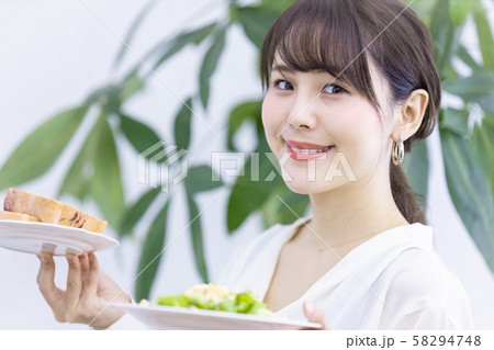 食事を運ぶ若い女性 58294748