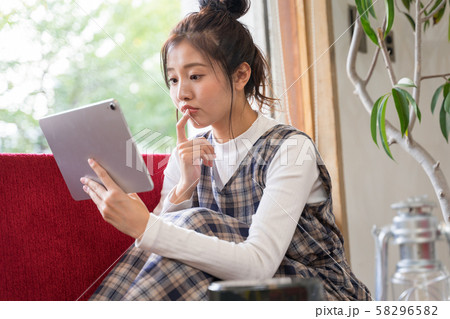 若い女性がキャンプの準備でタブレットで調べ物 58296582