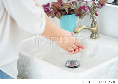 The woman hand is going to open the faucet to wash 58311570