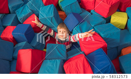 Indoor leisure activities, sports, recreation. Fun for preschoolers. Boy with arms raised up in mid Indoor leisure activities, sports, recreation. Fun for preschoolers. Boy with arms raised up in mid 58312573