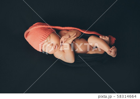 a newborn baby sleeps in a red Christmas hat on a black background. the concept of a healthy lifestyle, ECO, Christmas, new year holidays a newborn baby sleeps in a red Christmas hat on a black background. the concept of a healthy lifestyle, ECO, Christmas, new year holidays 58314664