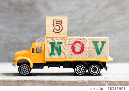 Truck hold letter block in word 5nov on wood background  58315908
