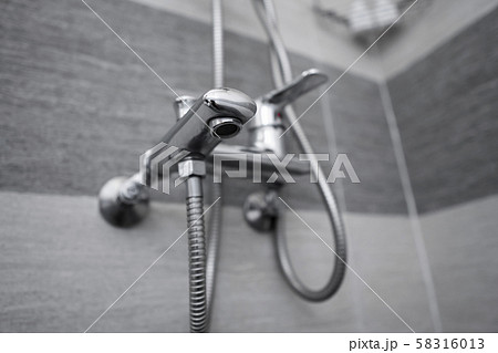 Modern designer tap and shower in bathroom. Closeup of chrome shower, faucet, in the bathroom 58316013