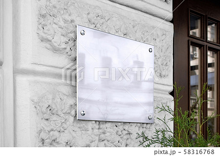 Blank silver glass signboard on textured wall mockup 58316768