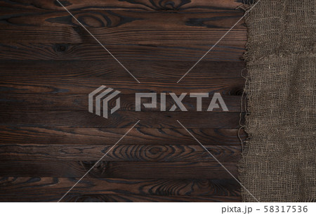 Old burlap fabric napkin on brown wooden background, top view 58317536