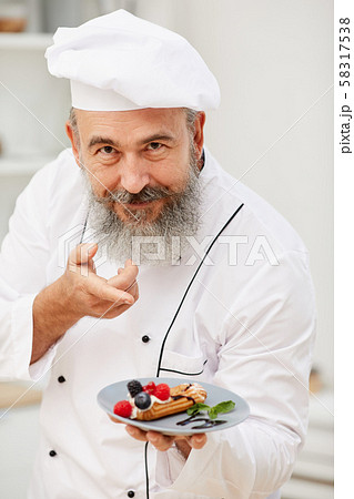 Senior Chef Presenting Dessert 58317538