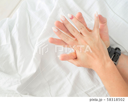 Close up hands of a couple make love hot sex on a white sheets Close up hands of a couple make love hot sex on a white sheets 58318502