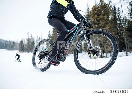 Midsection of mountain biker riding in snow outdoors in winter. 58318635