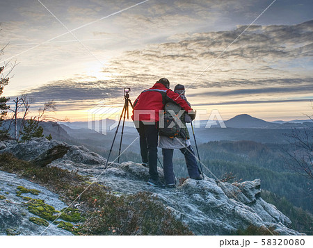 Two wildlife photographers at tripod with set  58320080