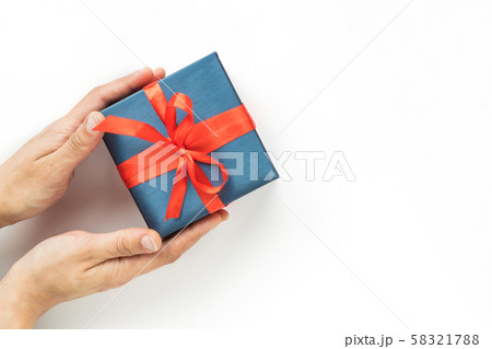 Blue Gift box with red ribbon in womans hands on 58321788
