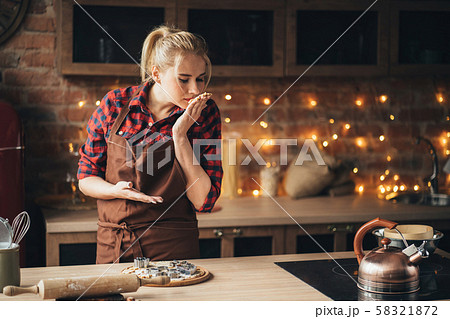 Woman cutting cookies of raw gingerbread dough Woman cutting cookies of raw gingerbread dough 58321872