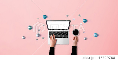 Christmas ornaments with person using a laptop computer 58329788